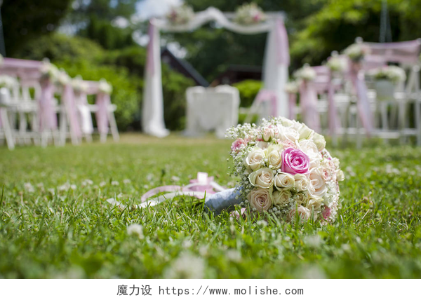 草地婚礼的现场景观和手捧花与玫瑰婚礼花束